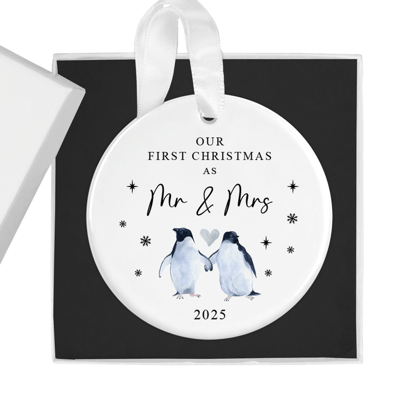 ceramic ornament with two penguins holding flippers beneath a heart