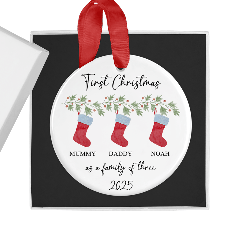 Personalised ceramic ornament with three bright red stockings hanging from a festive garland