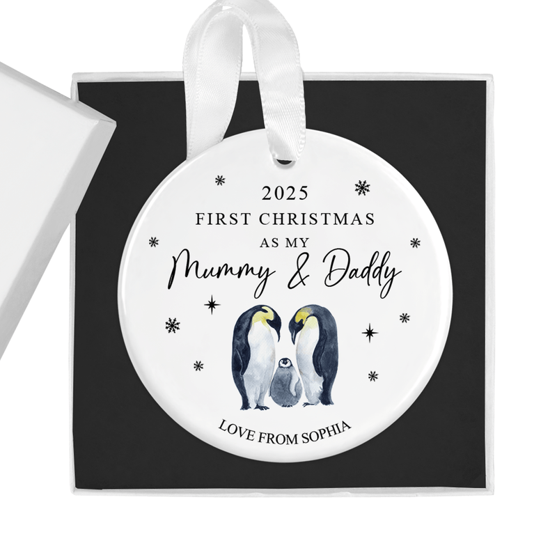 Personalised ceramic ornament with two parent penguins lovingly standing beside their chick