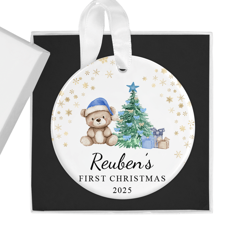 Personalised ceramic ornament with a cuddly teddy in a blue Santa hat beside a Christmas tree